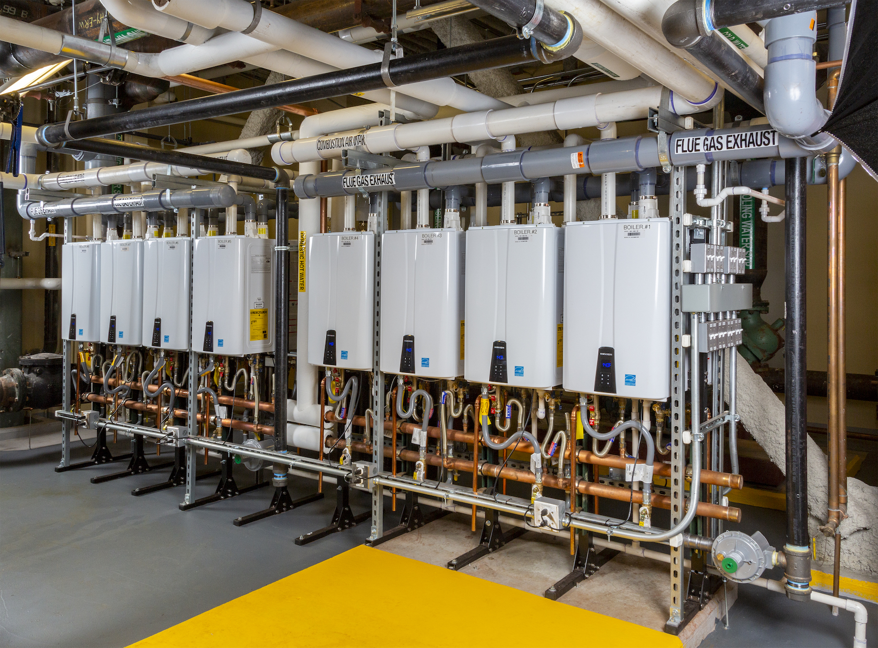 Sixteen Navien NPE tankless water heaters in two back-to-back banks of eight serve 170 residences in the West End Asteria Apartments, Boston. 