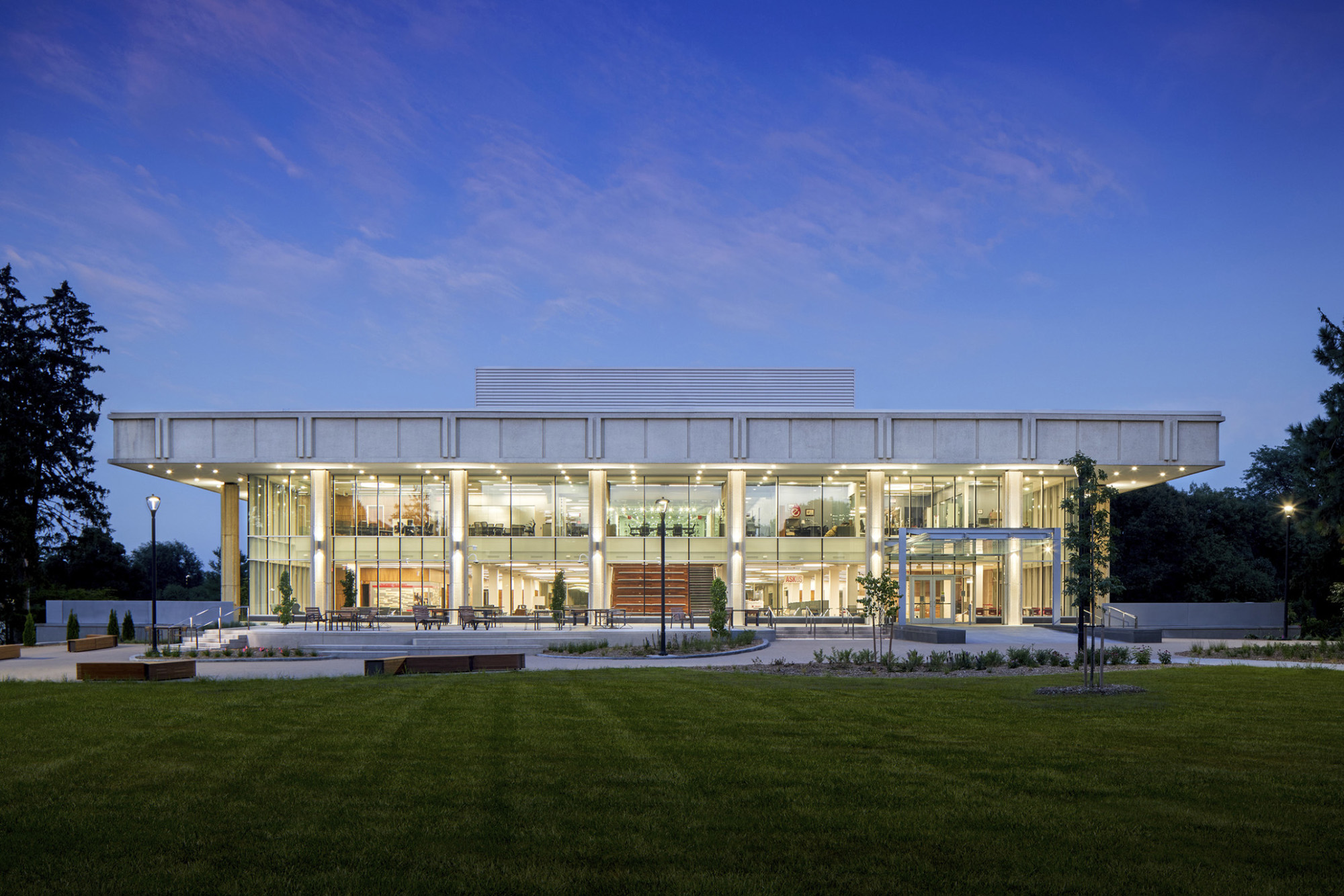 Evening view of a two story academic building light up from within shining out through full glass windows