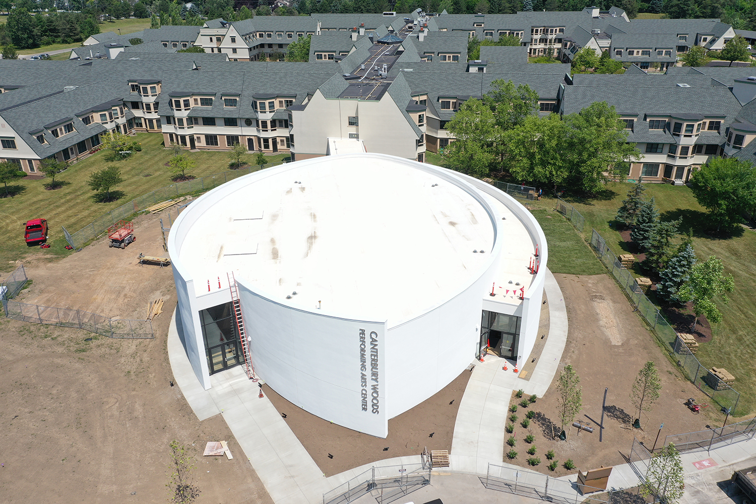 Aerial view of white building with rounded sides with “Canterbury Performing Arts Center” shown on the front 