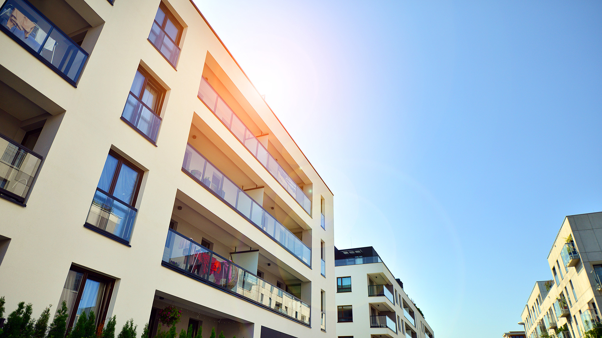 Exterior of new multifamily building on a blue cloudy sky background