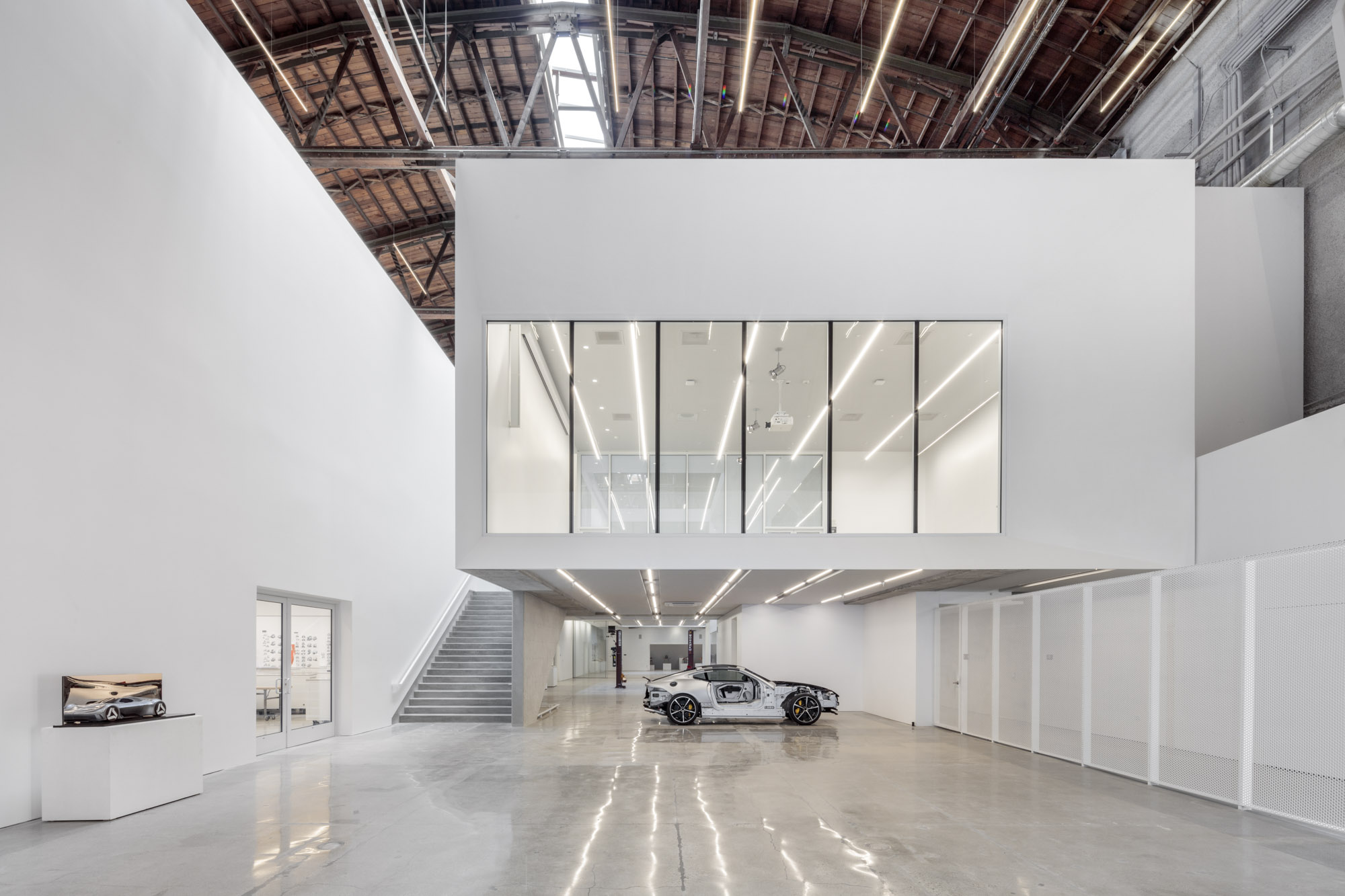 This image from the Fabrication Lab on level one features a “cut away” Jaguar F-Type and shows the hovering flexible lecture / gallery space above. Photo: Joshua White