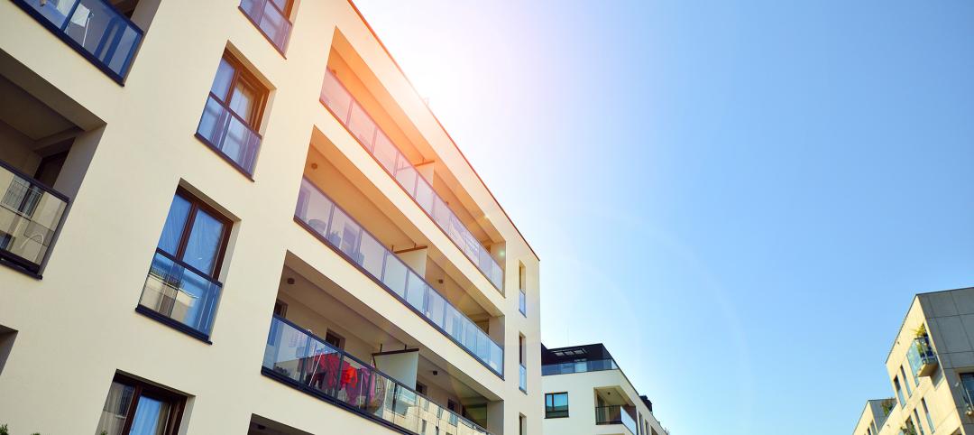 Exterior of new multifamily building on a blue cloudy sky background