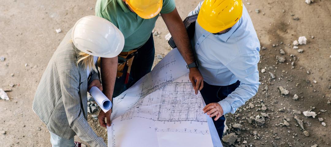 A group of architects work together on-site, discussing blueprints and coordinating to bring their project to life.