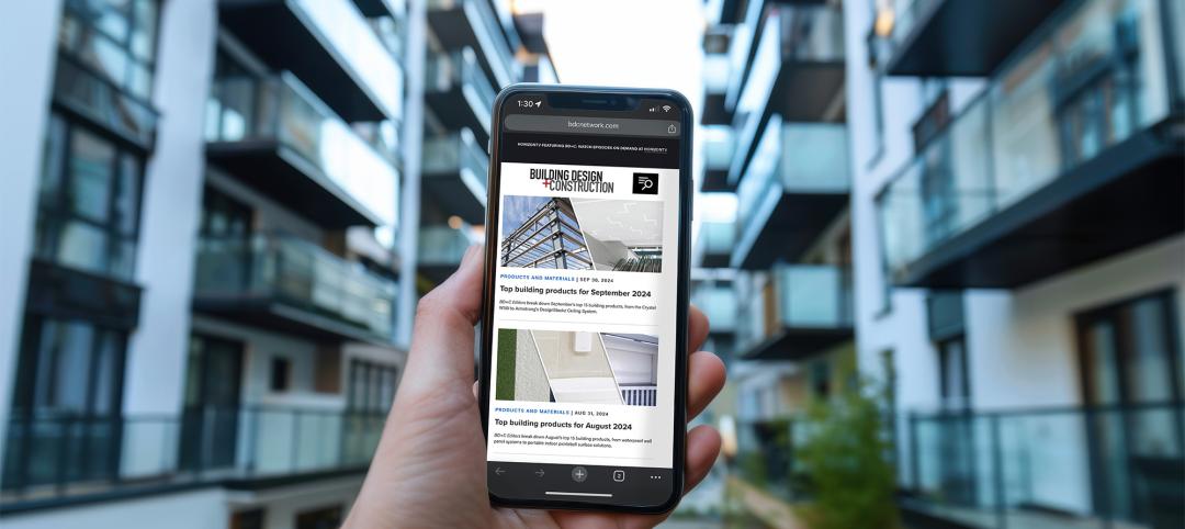 Hand holding smartphone in front of modern apartment building